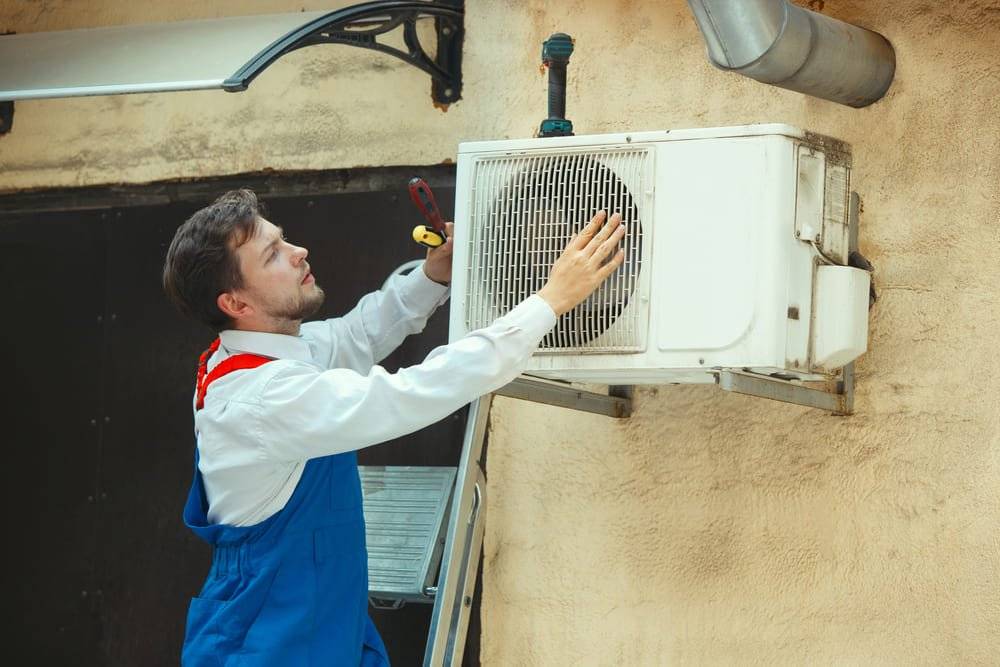 Plombier installant une climatisation